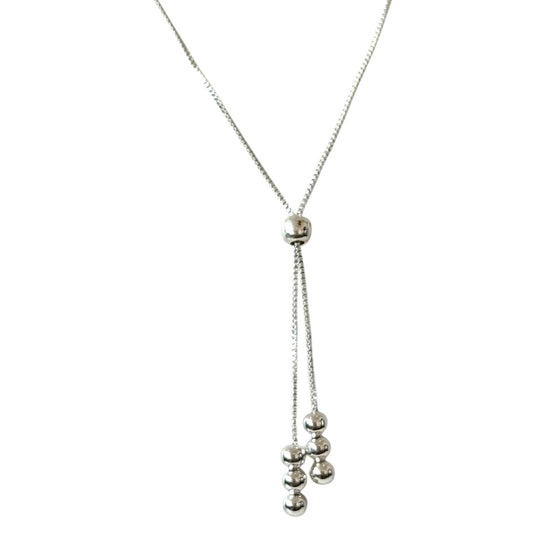 Silver necklace with hanging beads on a white background