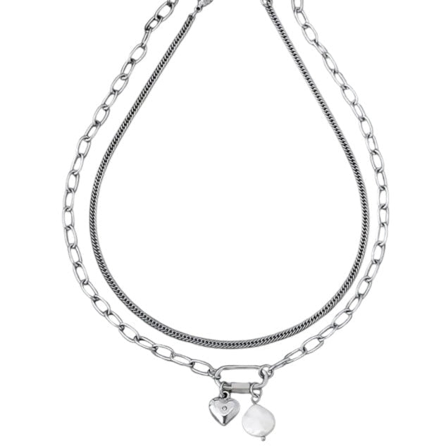 Stack of silver chain necklaces with heart pendants on a white background