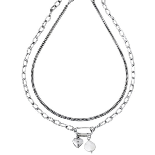 Stack of silver chain necklaces with heart pendants on a white background